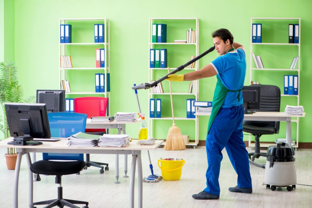 Janitorial service San Jose CA worker vacuuming green-walled office space